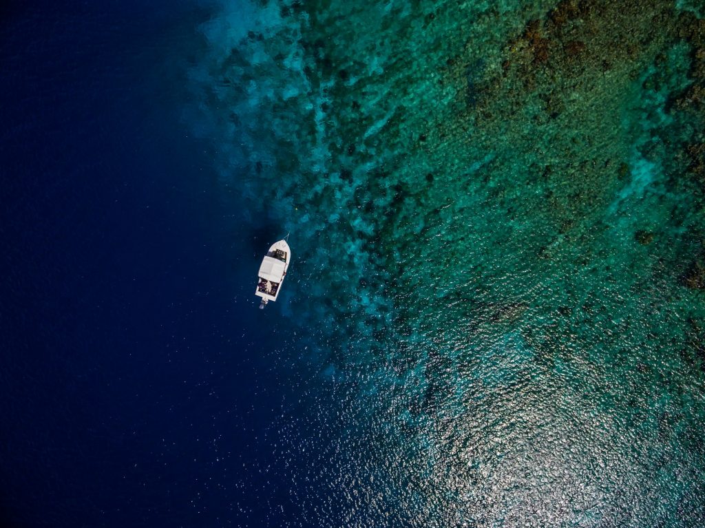 Aerial shot of a boat on the beautiful blue ocean in Bonaire, Caribbean