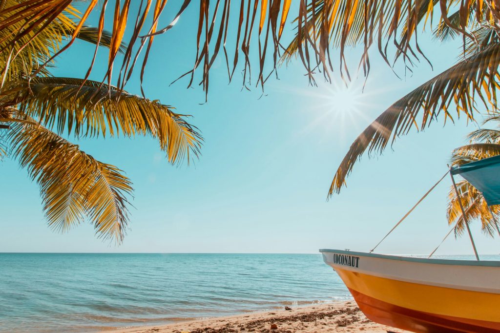 Beautiful view from the beach to the azure ocean and a boat in Southern Belize.